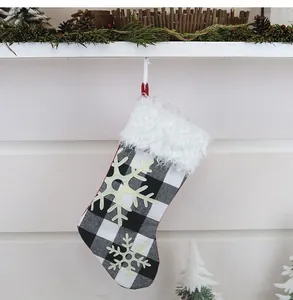 Close-up of buffalo check Christmas stocking with plush faux fur trim and snowflake patterns