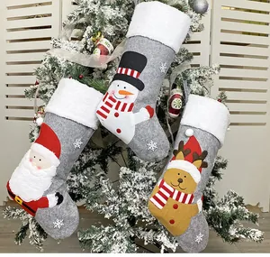 Close-up of three grey Christmas stockings with Santa, Snowman and Reindeer embroidery