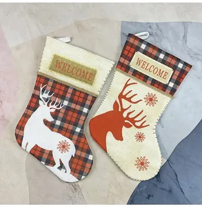 Detail of Christmas stocking set with reindeer prints and Welcome tag on rustic canvas