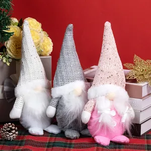 Three Christmas gnomes with sequined hats in pink and white on a festive red background