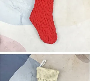 Close-up of cable knit patterns and fabric hanging loop on red and beige Christmas stockings