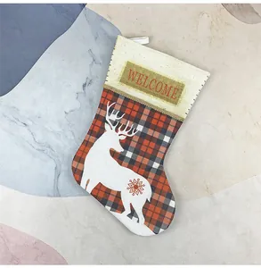 Detail of red buffalo plaid Christmas stocking with reindeer print and Welcome text