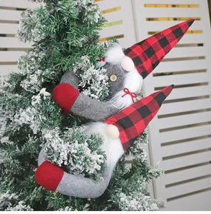 Detail of grey gnome curtain fasteners with red plaid hats hugging a Christmas tree