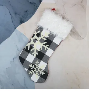 Detail of buffalo plaid Christmas stocking with white faux fur trim and snowflake applique