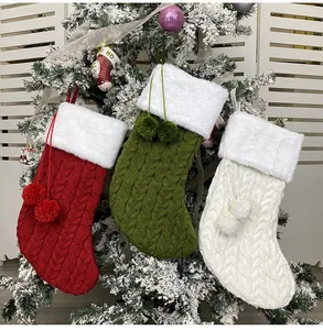Detailed knit texture of red green and white Christmas stockings with faux fur trim and pom-poms