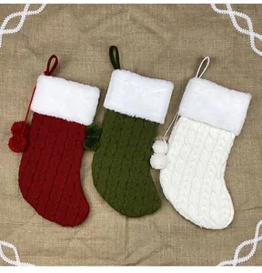 Detail of knitted Christmas stockings in red, green and ivory with plush faux fur cuffs