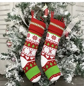 Dettaglio calze di Natale in maglia rosse e bianche con motivi a fiocchi e passanti