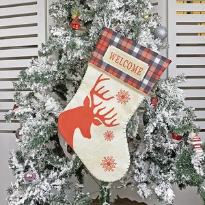 Christmas stocking with red reindeer silhouette and plaid trim hanging on a tree