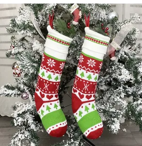 Dettaglio di calze di Natale in maglia con fiocchi di neve su albero innevato