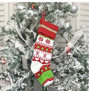 Dettaglio di una calza natalizia lavorata a maglia rossa e bianca sull'albero