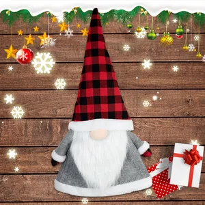 Christmas gnome plush topper with red buffalo plaid hat on a festive wooden background