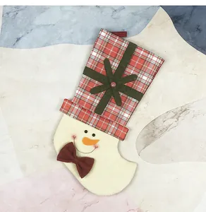 Detail of red plaid Christmas stocking with snowman face and white faux fur trim decor