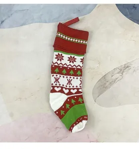 Dettaglio calza di Natale in maglia rossa e bianca con motivi festivi a fiocchi di neve