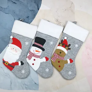Three grey Christmas stockings with Santa Claus, snowman and reindeer plush characters