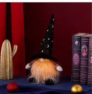 Detail of glowing Halloween gnome with starry hat and warm LED light in a cozy setting