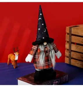 Dettaglio di gnomo di Halloween con cappello a luna e stelle e abito a quadri arancione