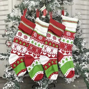 Set di 4 calze di Natale in maglia con motivi a fiocco di neve appese all'albero festivo