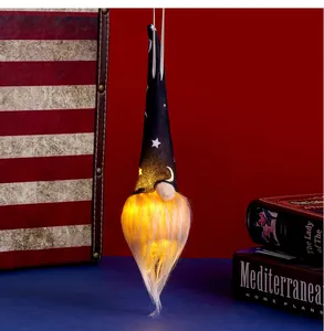 Close-up of a hanging Halloween gnome with glowing LED beard and star moon pattern hat