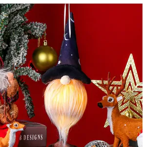 Détail d'un gnome d'Halloween lumineux avec motifs lune et étoiles sur chapeau noir
