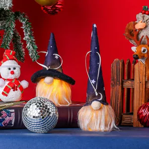 Close-up of glowing Halloween gnomes with star patterns on hats and warm LED lights