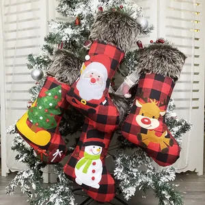 4er-Set Weihnachtssocken mit Karomuster und Plüschrand an einem verschneiten Baum