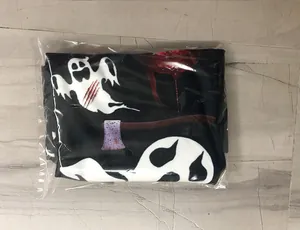 Detail view of Halloween ghost and bloody axe printed fabric in clear plastic packaging