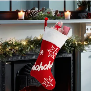 Macro view of red knit Christmas stocking with white faux fur cuff and hohoho text