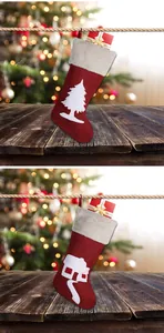 Detail of red Christmas stockings with plush white trim and gift boxes on wood