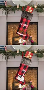 Detail von roten Weihnachtssocken mit Karomuster Plüschbesatz und Rentier Stickerei