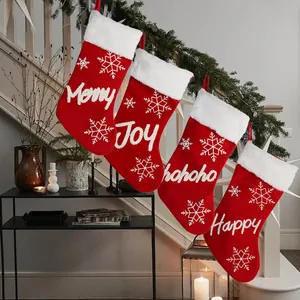 Set of four red plush Christmas stockings with white snowflakes and festive greetings