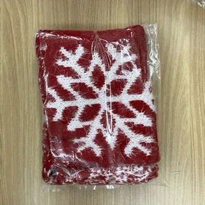 Macro detail of red knitted Christmas stocking with white snowflake pattern in packaging