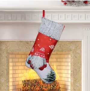 Detail of red Christmas gnome stocking with white knit hat hanging by a warm fireplace