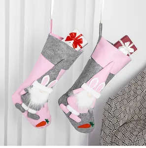 Dettaglio di calze pasquali a forma di gnomo rosa e grigie con orecchie di coniglio