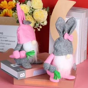 Osterhasen-Gnome mit Karotten-Deko auf einem rosa Buch für die Heimdekoration