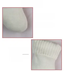 Détail d'une chaussette de Noël en tricot blanc montrant la texture côtelée et le fil doux