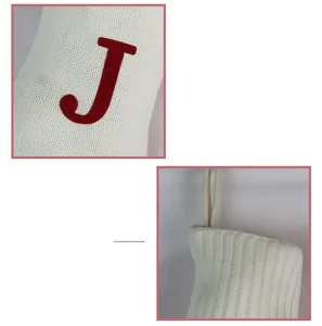 Gros plan détaillé de la chaussette de Noël en tricot crème avec lettre J brodée rouge