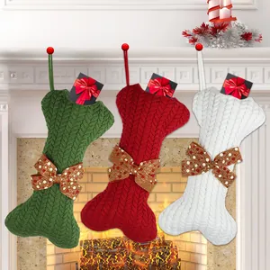 Detail of three knitted bone-shaped Christmas stockings on a cozy fireplace mantel