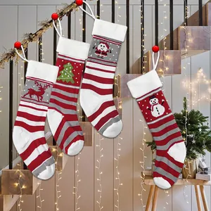 Set of 4 knitted Christmas stockings with reindeer and Santa hung on a festive staircase