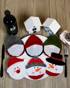 Detalle de fundas navideñas para cubiertos con motivos de Papá Noel y muñeco de nieve