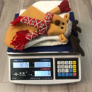 Close-up of reindeer Christmas decoration on scales weighing 121.5 grams