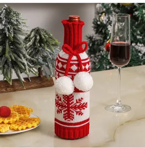 Close-up of knitted snowman wine bottle cover with snowflake patterns and white pom-poms