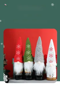 Detail of knitted Christmas gnome wine bottle covers with snowflake embroidery