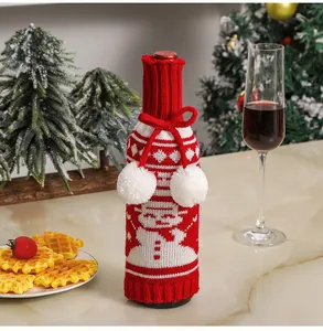 Close-up of knitted snowman wine bottle cover with white pom-poms for Christmas dinner decor