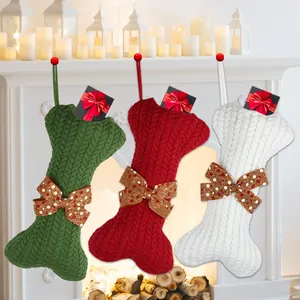 Three large bone-shaped knitted Christmas stockings in green red and white colors