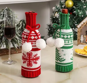 Detail of knitted Christmas wine bottle covers with snowflakes, trees and pom-pom ties