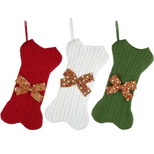 Three-pack knitted bone-shaped Christmas stockings in red, cream, and green for gift hanging