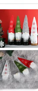 Detail of four Christmas gnome wine bottle covers with knitted snowflake hats and plush beards