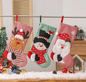 Three knit Christmas stockings with reindeer snowman and Santa appliques hanging on a rack