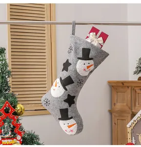 Detail of grey felt Christmas stocking with 3D snowman motifs and gift box inside