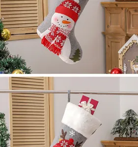 Detail of gray felt Christmas stocking with snowman embroidery and festive gift box inside
